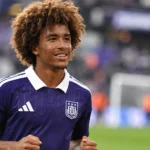 Een jonge Anderlecht-speler in paars tenue tijdens een rustige warming-up op het veld.