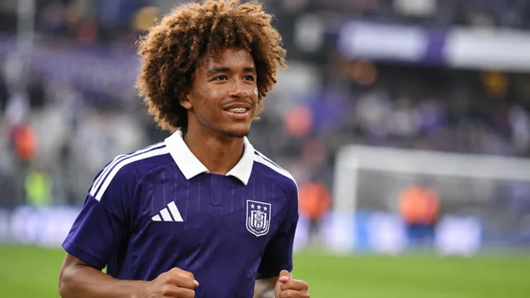 Een jonge Anderlecht-speler in paars tenue tijdens een rustige warming-up op het veld.