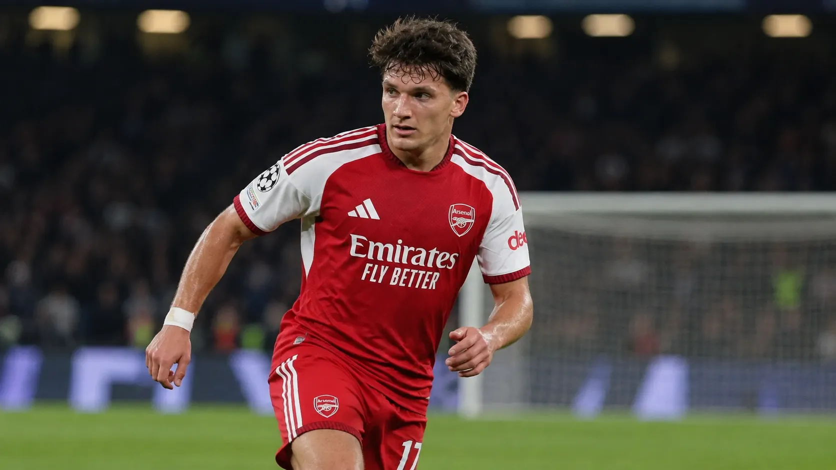 Christos Tzolis in Arsenal-tenue op het veld tijdens een avondwedstrijd.