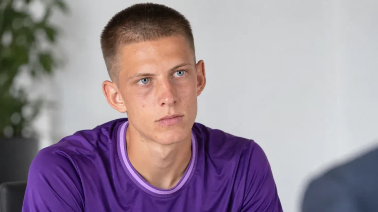 Lars Montegnies in een paarse voetbaltrui tijdens een rustig redactioneel portret.