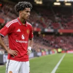 JJ Gabriel in het rode shirt van Manchester United tijdens een rustig moment op het veld.