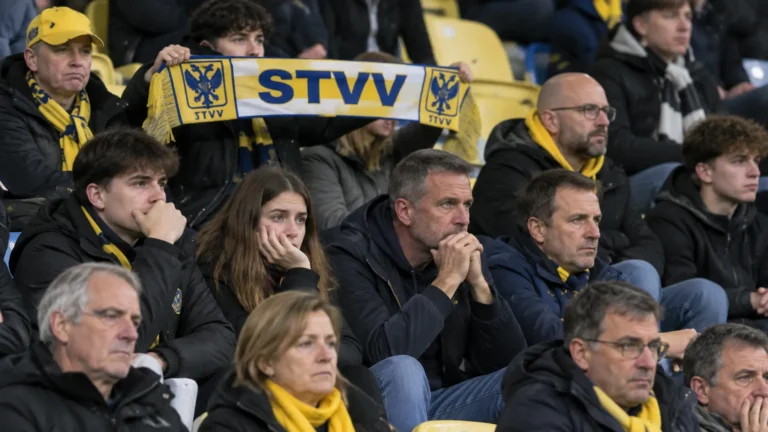 Een groep STVV-supporters in de tribune met een blauw-geel-witte sjaal.