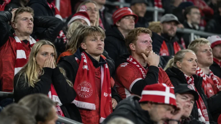 Deense supporters in een stadiontribune met een sjaal van de nationale ploeg.