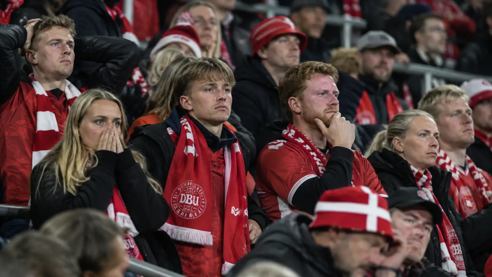 Deense supporters in een stadiontribune met een sjaal van de nationale ploeg.