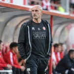 Een staflid van KV Kortrijk naast de dug-out in het Guldensporenstadion.