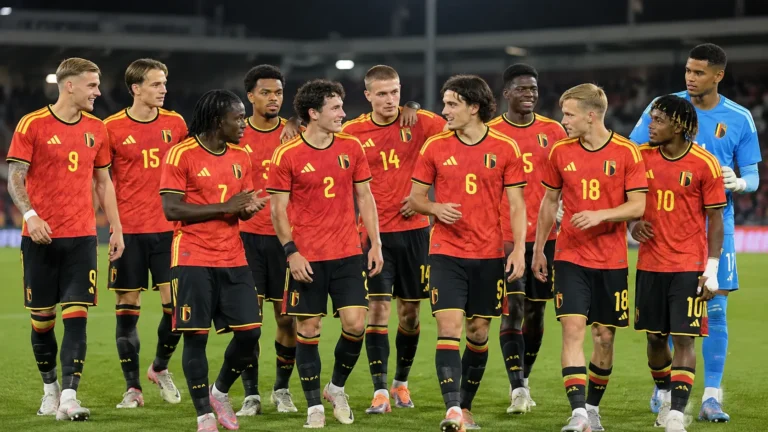 Belgische U21-spelers in rode tenues verzamelen op het veld na een wedstrijd.