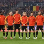 Belgische internationals staan opgesteld voor een interland in een vol stadion.