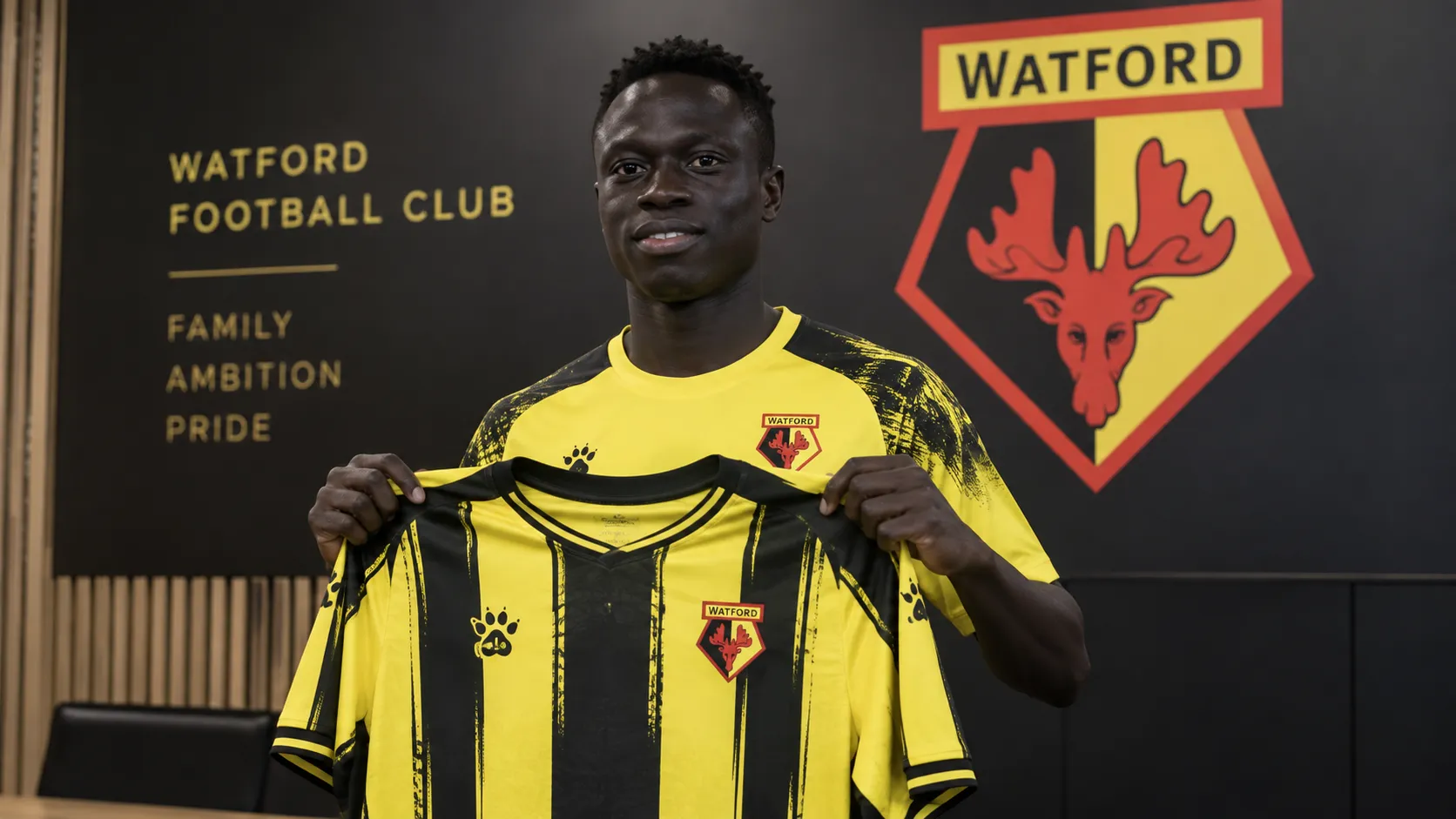 Krépin Diatta poseert tijdens zijn officiële voorstelling bij Watford in clubtenue.