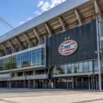 De gemoderniseerde Noordtribune van het Philips Stadion met een PSV-embleem aan de gevel.