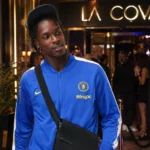 Emmanuel Emegha verlaat ’s avonds een nachtclub in Parijs in een blauwe Chelsea-trainingsjas.