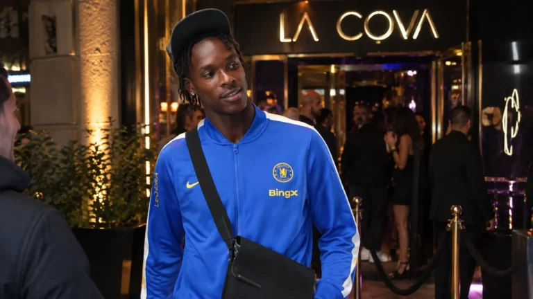 Emmanuel Emegha verlaat ’s avonds een nachtclub in Parijs in een blauwe Chelsea-trainingsjas.