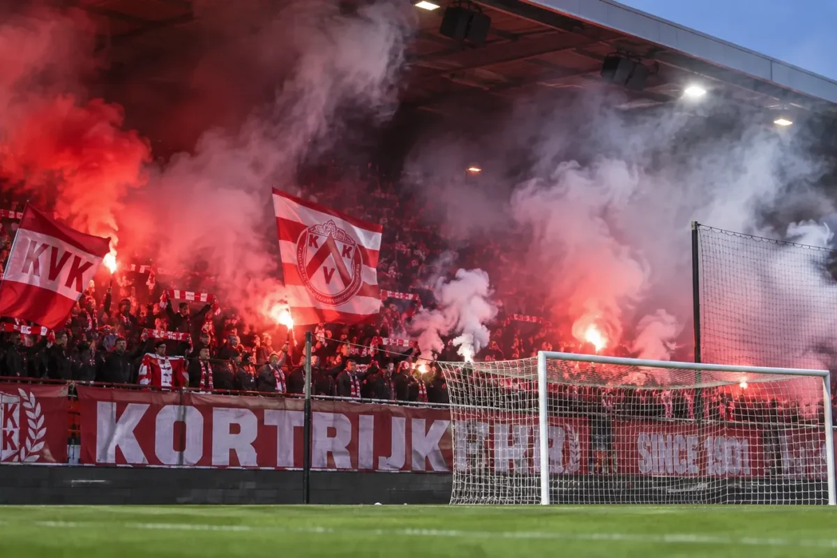 Rood-witte supporters van KV Kortrijk zorgen met rookfakkels voor sfeer achter het doel.