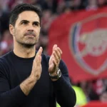 Mikel Arteta applaudisseert langs de zijlijn in een stadion.
