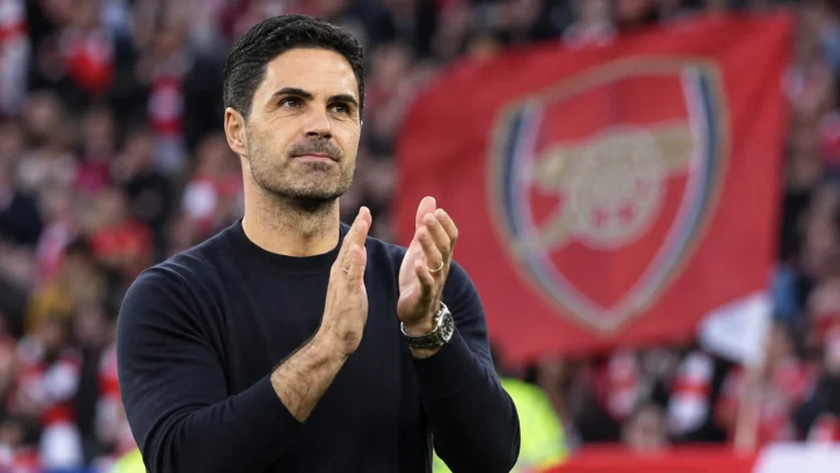 Mikel Arteta applaudisseert langs de zijlijn in een stadion.