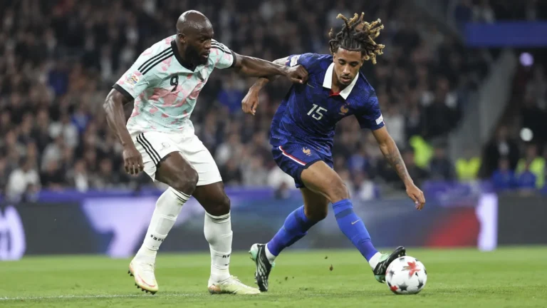 Twee voetballers vechten in een stadion om de bal.