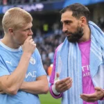 Twee Manchester City-spelers overleggen op het veld na een wedstrijd.