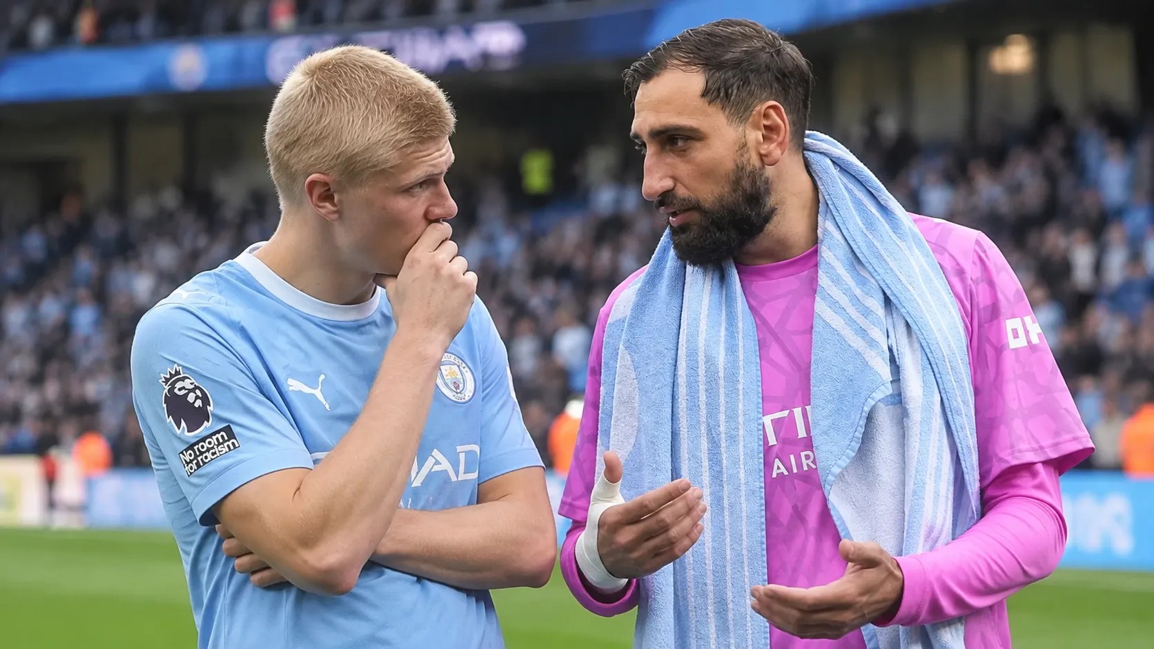 Twee Manchester City-spelers overleggen op het veld na een wedstrijd.
