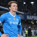Scott McTominay in een blauw Napoli-shirt tijdens een rustig moment langs het veld.