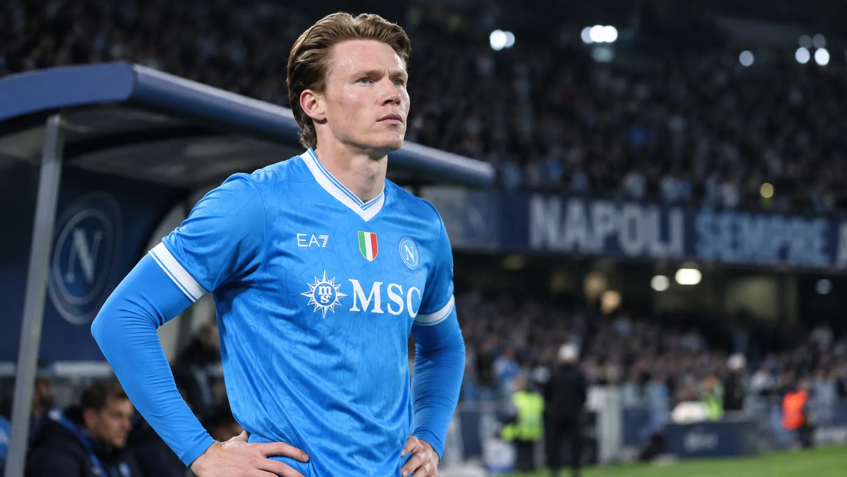 Scott McTominay in een blauw Napoli-shirt tijdens een rustig moment langs het veld.