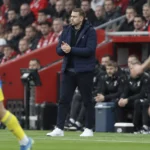 Tonda Eckert staat in een donkere jas langs de zijlijn tijdens een wedstrijd van Southampton.
