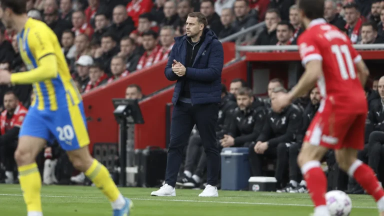 Tonda Eckert staat in een donkere jas langs de zijlijn tijdens een wedstrijd van Southampton.