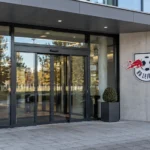 Een lege ingang van een RB Leipzig-clubgebouw met een fysiek geïntegreerd clubembleem.
