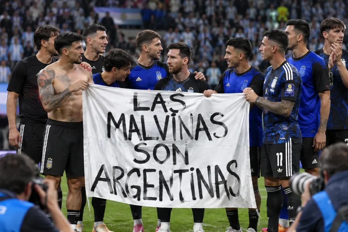 Argentijnse spelers en staf staan rond een groot spandoek aan de rand van het veld.