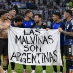Argentijnse spelers en staf staan rond een groot spandoek aan de rand van het veld.