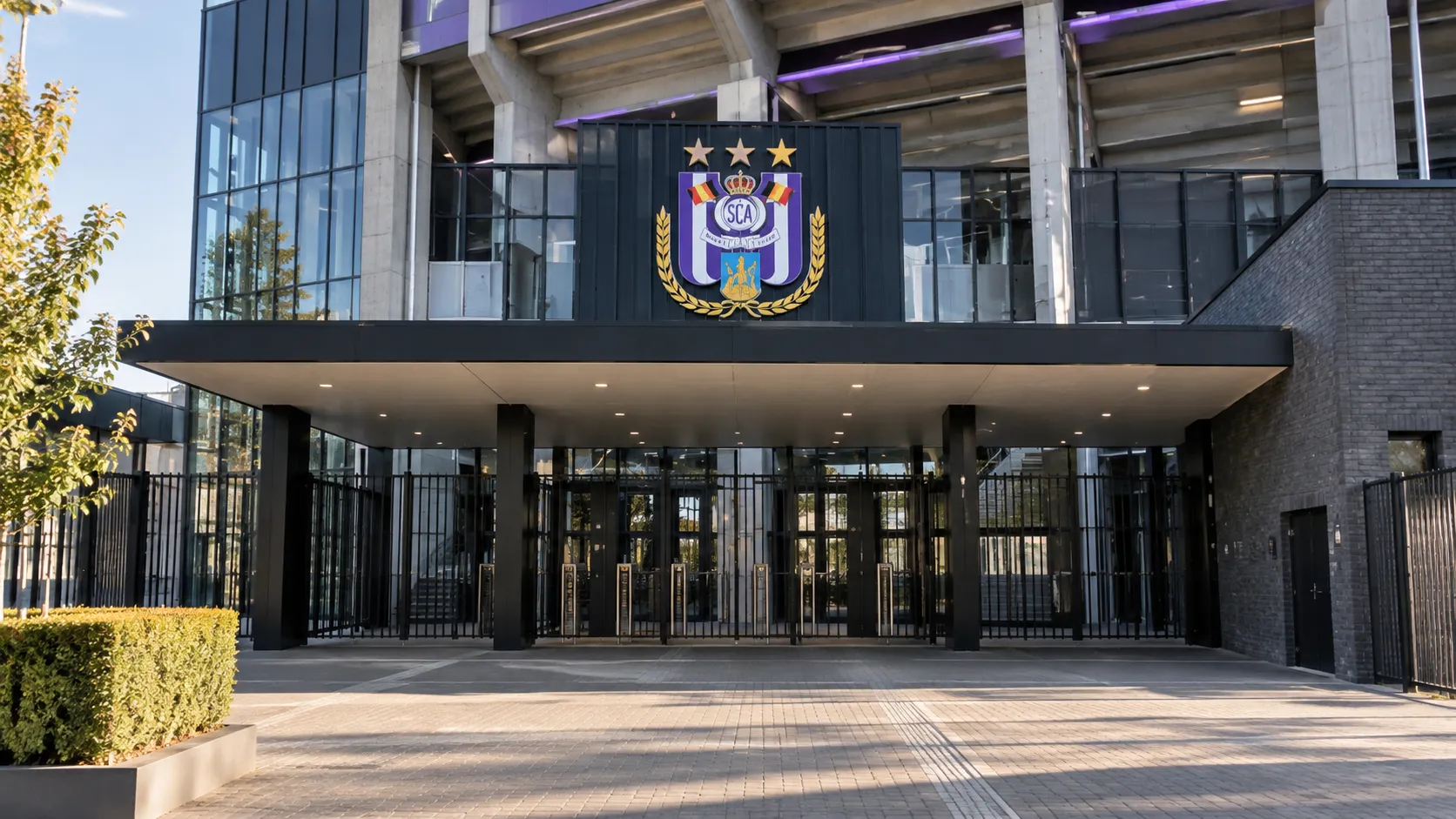De hoofdingang van het Lotto Park met een RSC Anderlecht-embleem op het gevelbord.