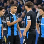 Club Brugge-spelers in zwart-blauwe wedstrijdkleding aan de zijlijn.