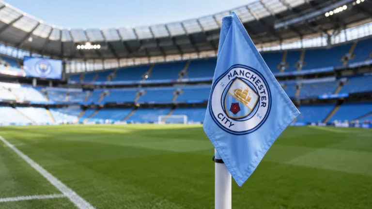 Manchester City-hoekvlag aan de rand van een leeg voetbalveld.