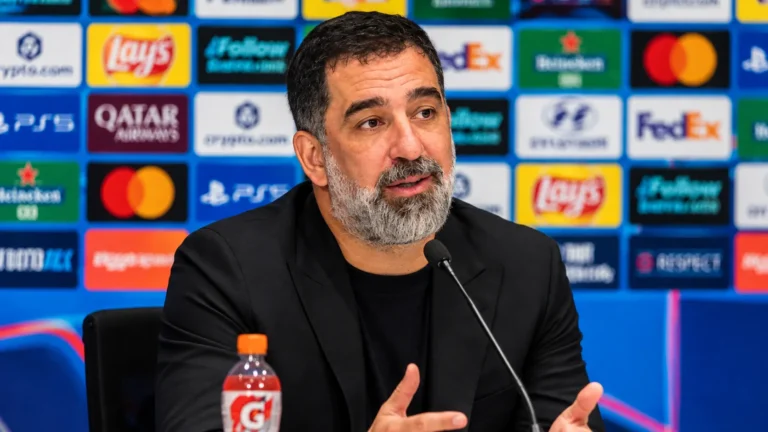Arda Turan tijdens een voetbalpersconferentie achter een microfoon.
