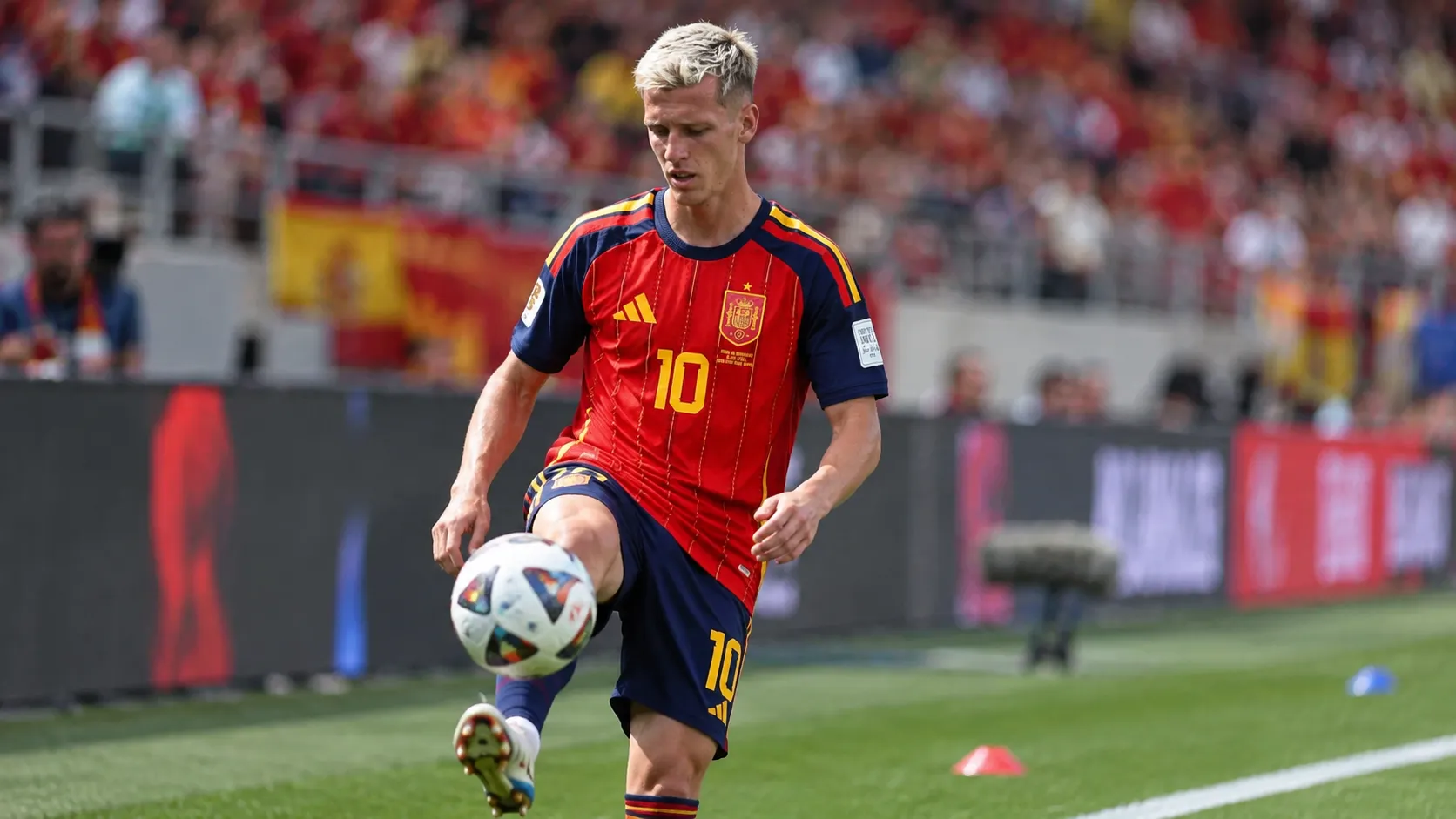 Dani Olmo warmt op in het Spaanse wedstrijdshirt aan de rand van een voetbalveld.