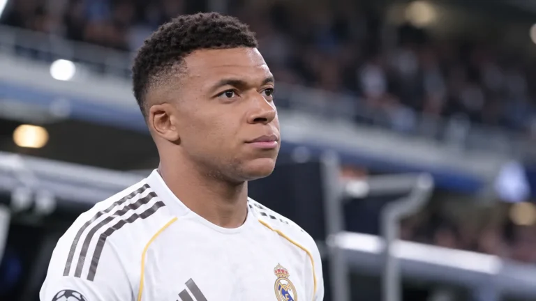 Kylian Mbappé in een wit shirt van Real Madrid in een stadionomgeving.