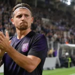 Adriano Bertaccini in een paars Anderlecht-shirt langs de zijlijn van een voetbalstadion.