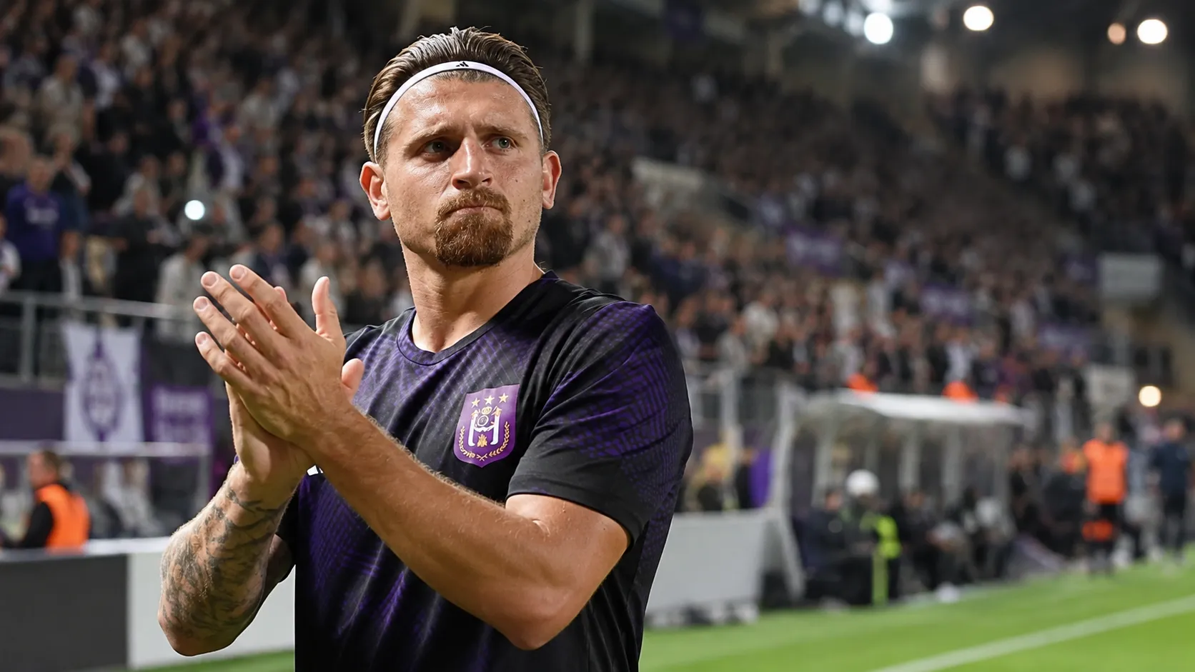 Adriano Bertaccini in een paars Anderlecht-shirt langs de zijlijn van een voetbalstadion.