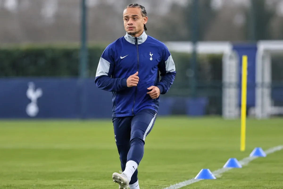 Xavi Simons in een blauw trainingsjack van Tottenham op een trainingsveld tijdens zijn revalidatie.