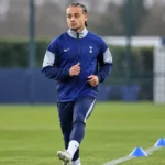 Xavi Simons in een blauw trainingsjack van Tottenham op een trainingsveld tijdens zijn revalidatie.