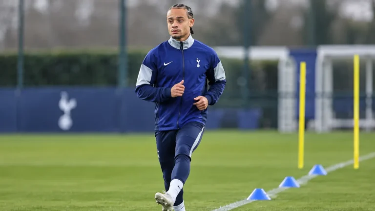 Xavi Simons in een blauw trainingsjack van Tottenham op een trainingsveld tijdens zijn revalidatie.