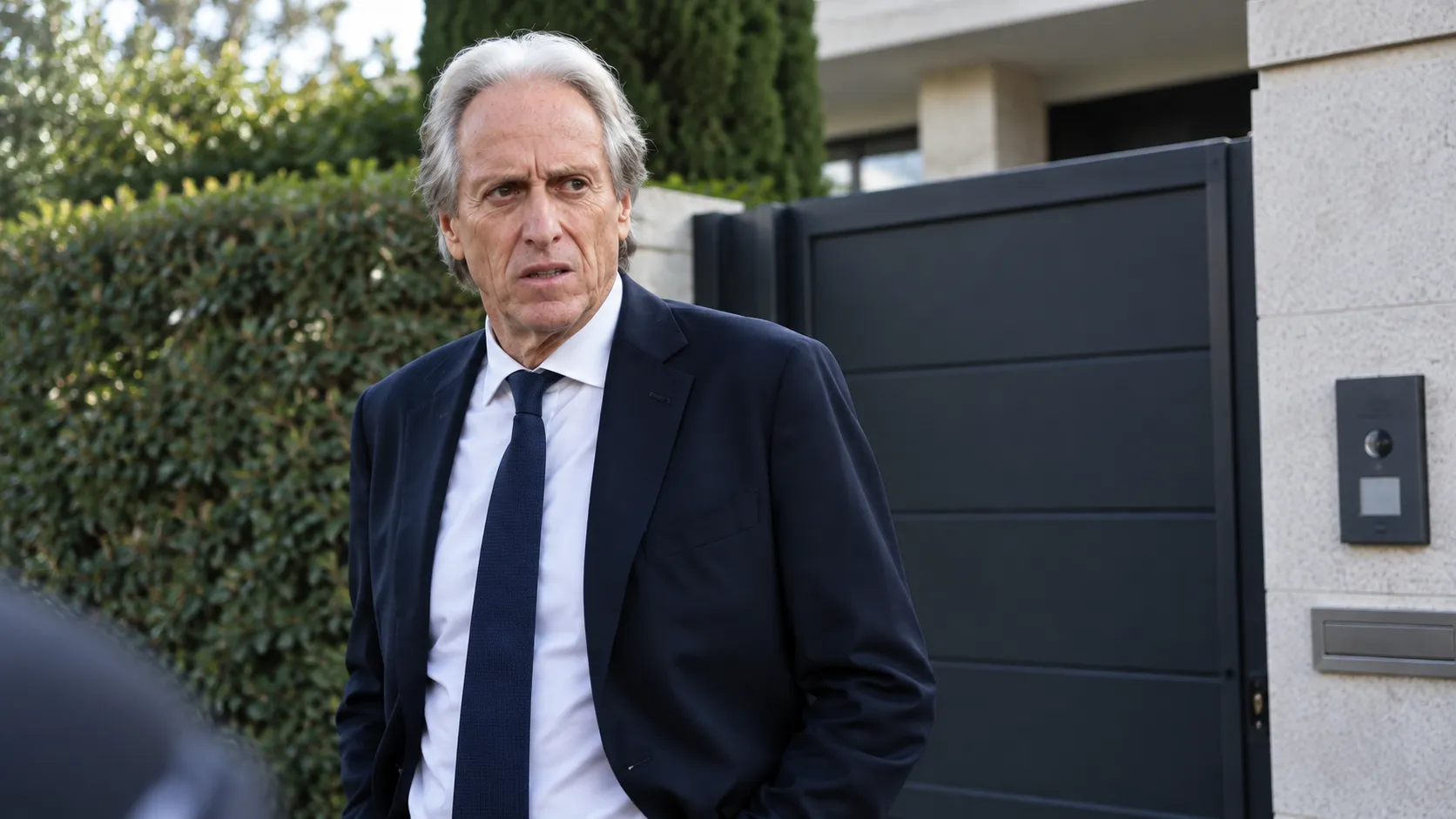 Jorge Jesus in donker pak bij de toegang van zijn woning.