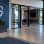 Lege inkomhal van de jeugdacademie van KRC Genk met een clubembleem op een vaste wandplaat.