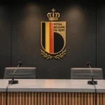 Lege interviewruimte van de KBVB met een embleem op de achterwand.