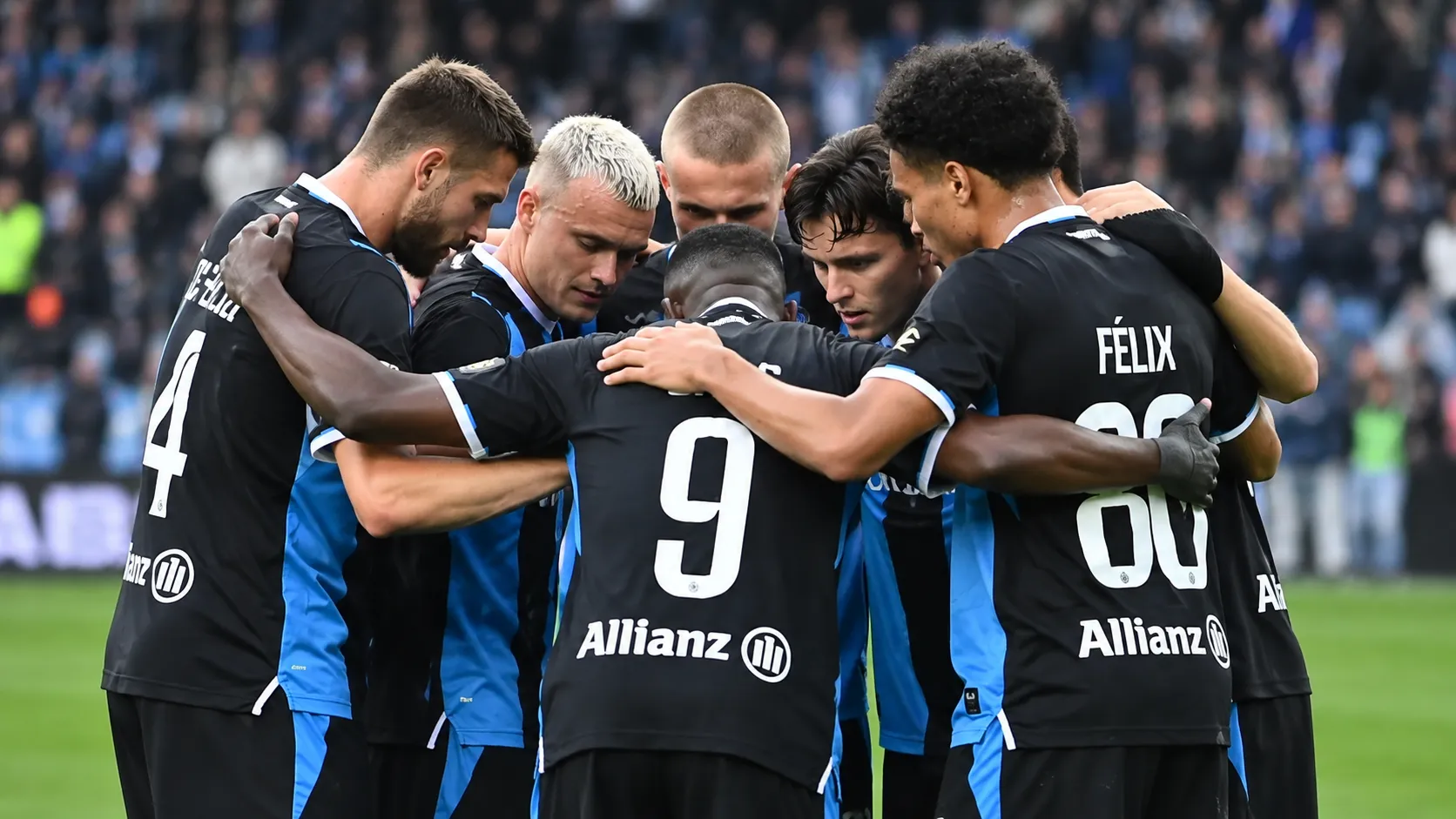 Een groep spelers van Club Brugge vormt een hechte huddle op het veld.