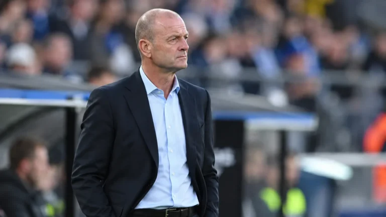 Jess Thorup staat geconcentreerd in de technische zone van een voetbalstadion.