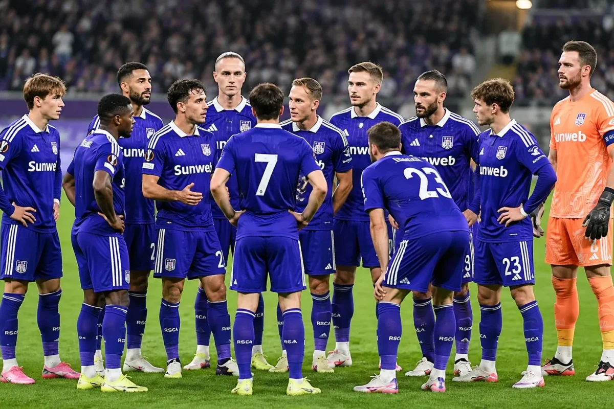 Een groep Anderlecht-spelers in blauw-paarse wedstrijdkleding verzamelt op het veld voor een wedstrijd.