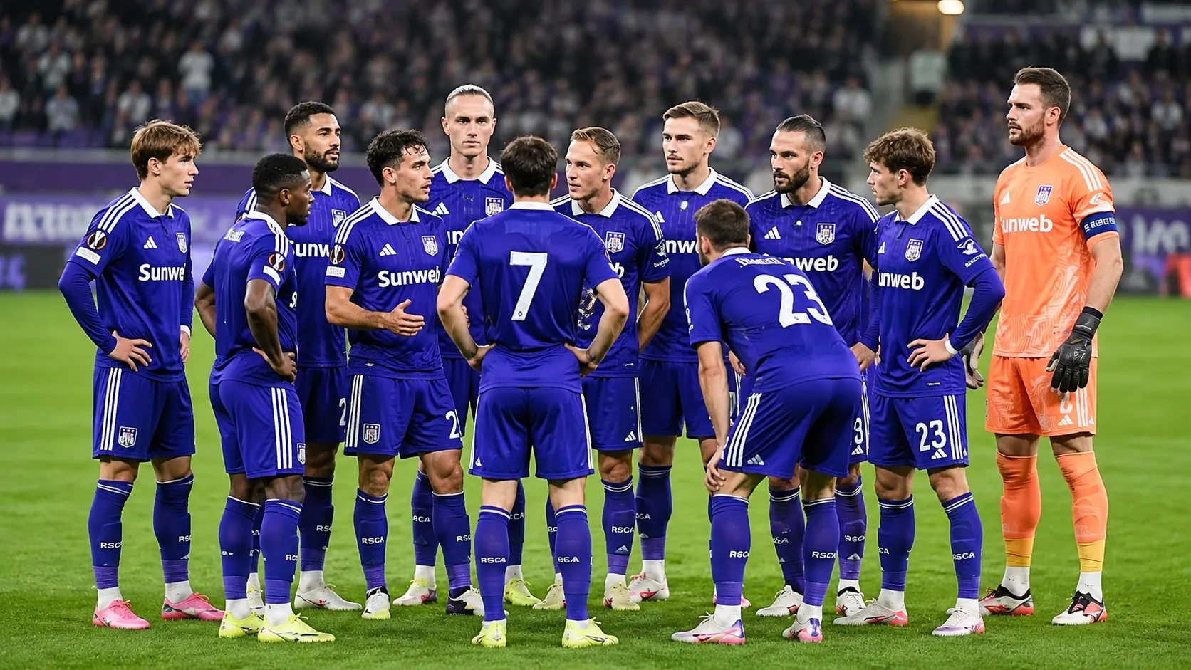 Een groep Anderlecht-spelers in blauw-paarse wedstrijdkleding verzamelt op het veld voor een wedstrijd.