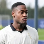 Martin Sherif in een wit Everton-shirt aan de rand van een trainingsveld.