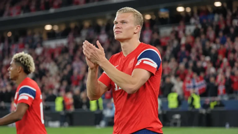 Erling Haaland in een rood Noors shirt terwijl hij na een WK-wedstrijd de supporters applaudisseert.