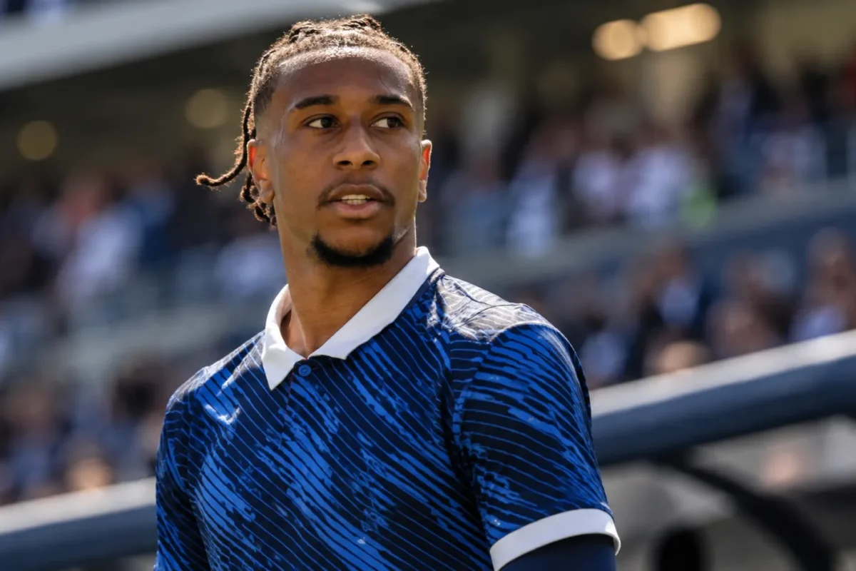 Michael Olise in een donkerblauw internationaal shirt langs de zijlijn van een stadion.