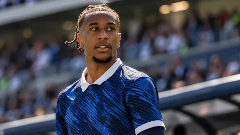 Michael Olise in een donkerblauw internationaal shirt langs de zijlijn van een stadion.